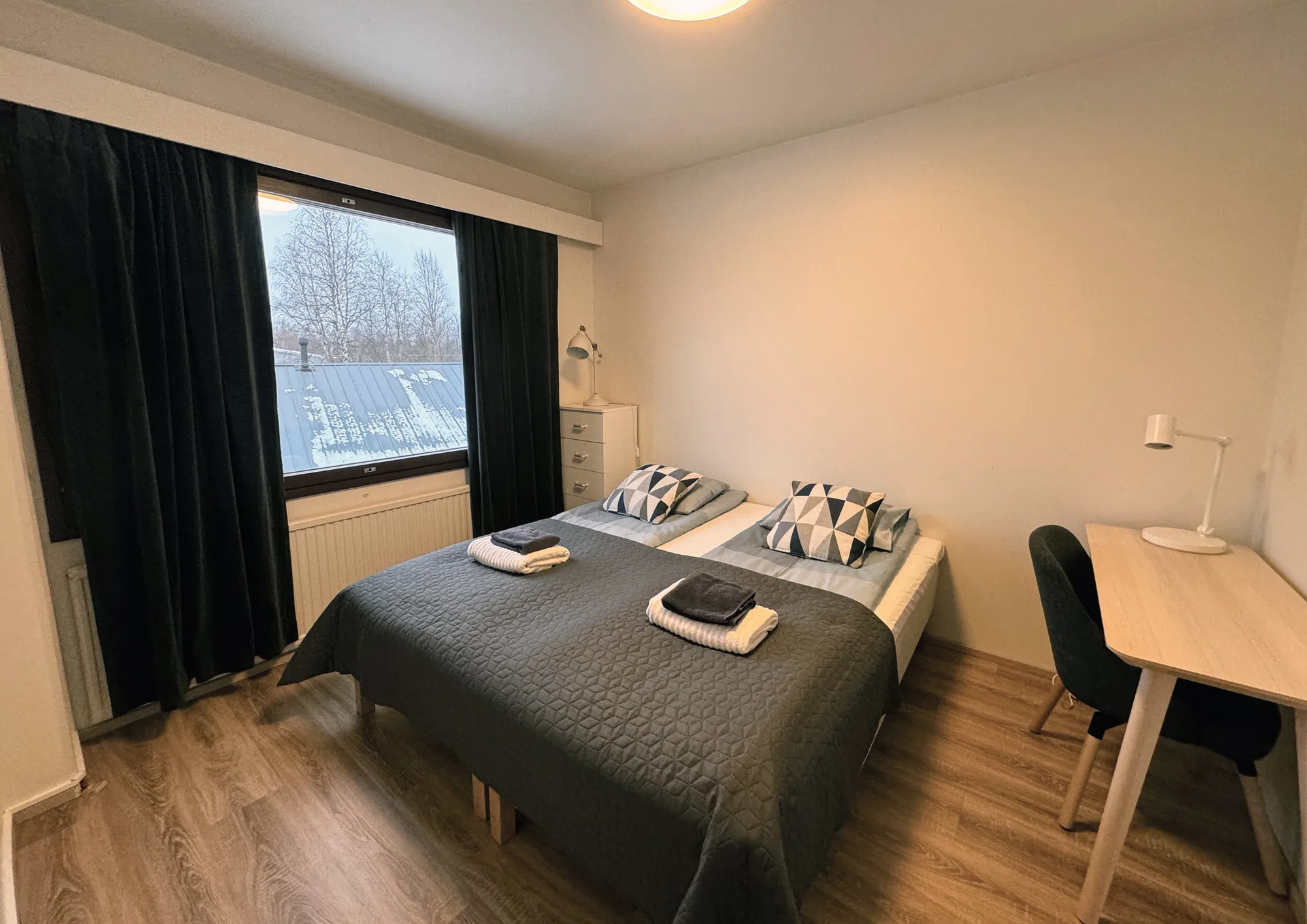 The bedroom of the Aurora Suite, two single beds pushed together under a window.