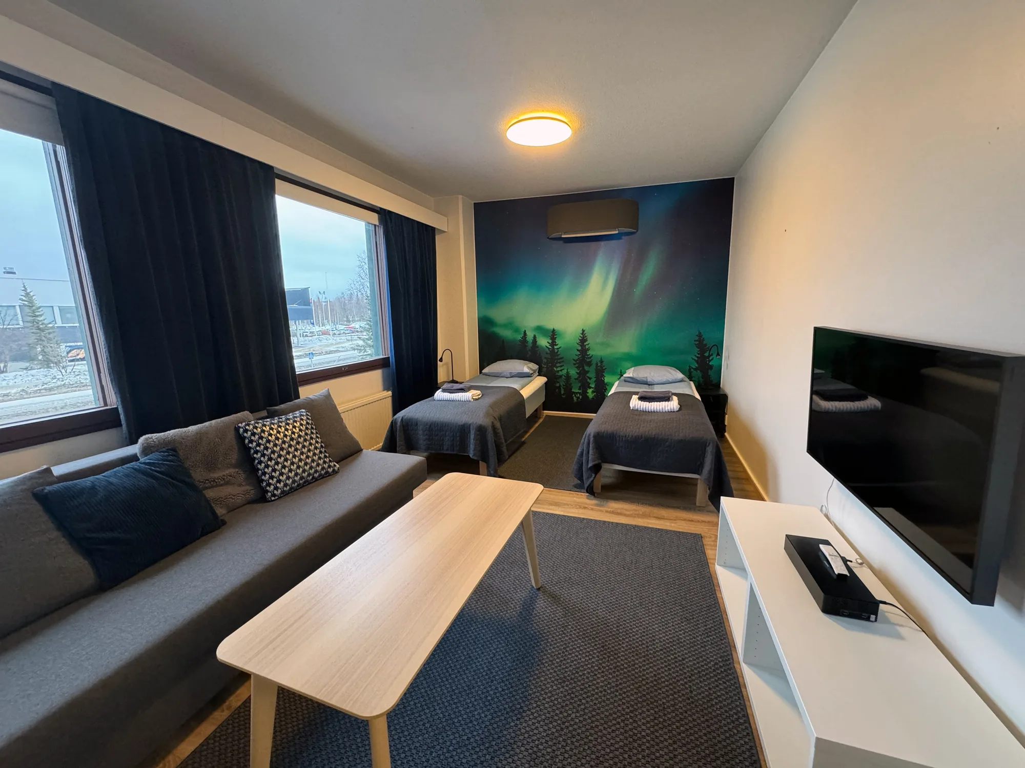 The living room of the Aurora Suite. An aurora is painted the full width of the wall behind the sofa.